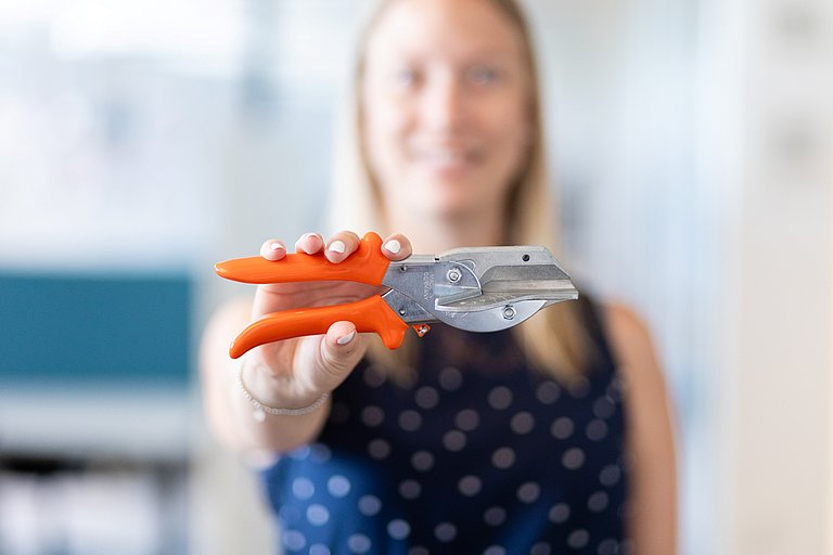Packungsschneider & Vera Steindl Vera Steindl hält einen Packungsschneider in der Hand