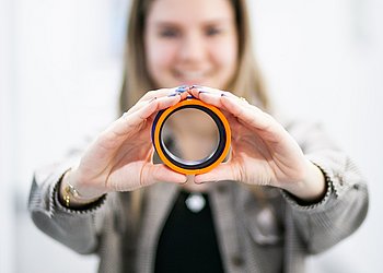 Hydraulikdichtung Simone Rakaseder hält Hydraulikdichtung in beiden Händen | HENNLICH